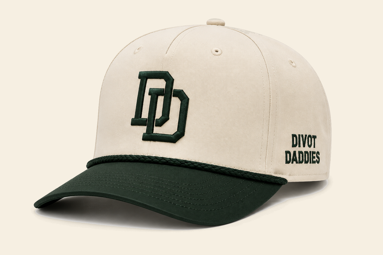Cream Divot Daddies hat with forest green brim, rope, DD monogram, and side embroidery
